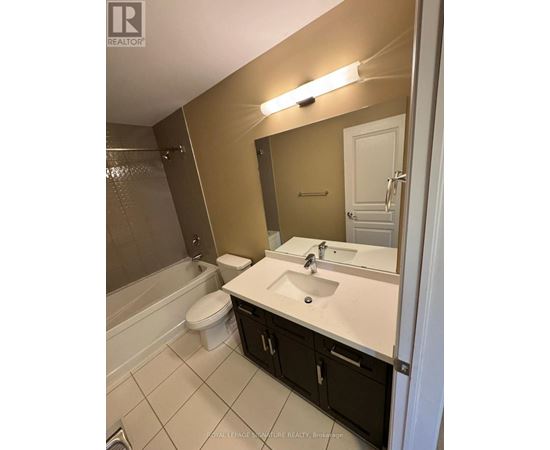 A bathroom with a toilet, sink, and mirror.