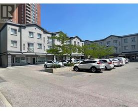 A parking lot with cars and apartment buildings in the background.