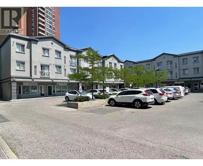 A parking lot with cars and apartment buildings in the background.