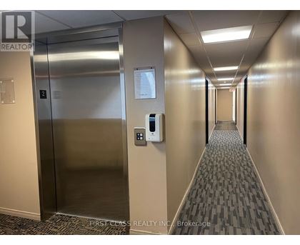 A hallway with a metal elevator and a wall-mounted parking meter.