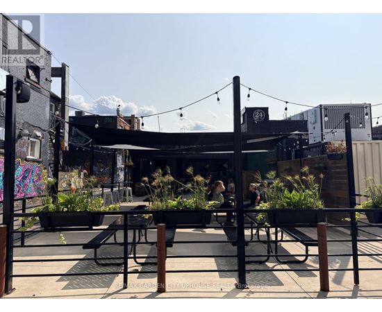 A patio area with tables and chairs and a bar in the background.