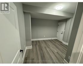 A room with wooden flooring and white walls.