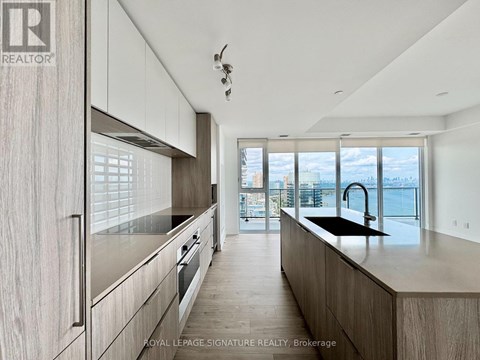 A modern kitchen with wooden cabinets and a view of the city.