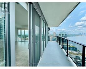 A balcony with glass doors overlooking a cityscape.
