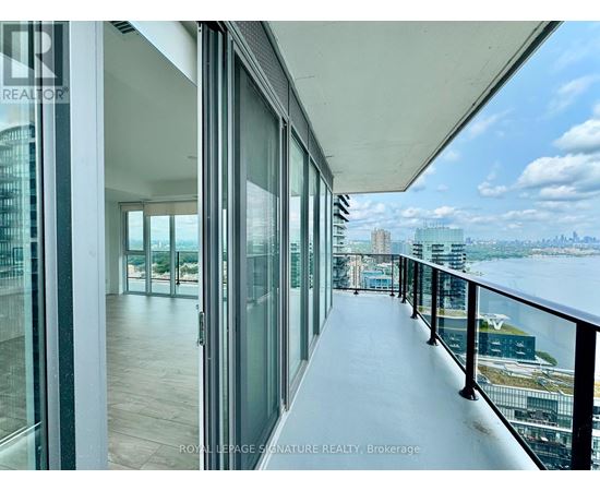 A balcony with glass doors overlooking a cityscape.