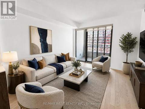A living room with a grey couch, a coffee table, and a painting on the wall.