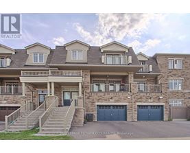 A large, multi-story residential building with a front yard and garage doors.