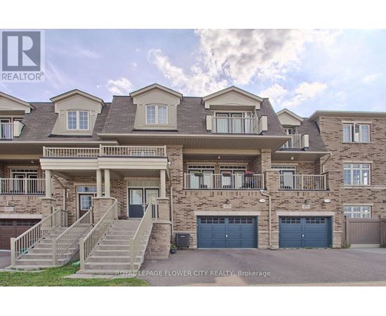 A large, multi-story residential building with a front yard and garage doors.