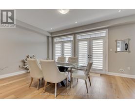 A dining room with a table and chairs.