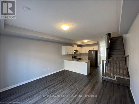 A spacious room with a staircase leading to the upper floor.