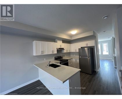A kitchen with white cabinets and a stainless steel refrigerator.