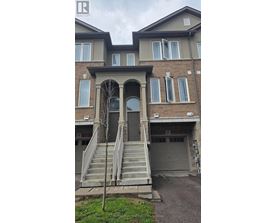 A house with a grey front door and a tree in front of it.
