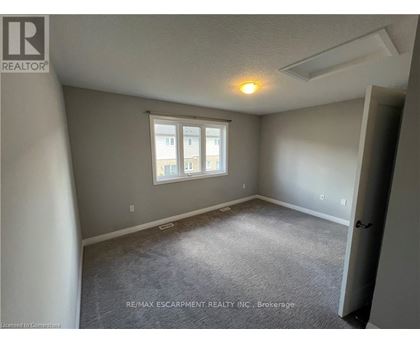 A room with a window and a carpeted floor.