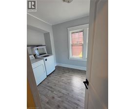 A room with a window and a washing machine.