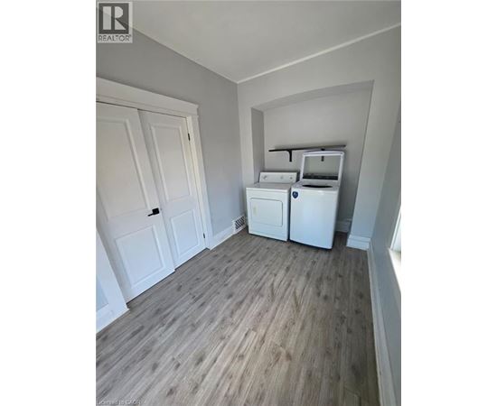 A kitchen area with a fridge, dishwasher and a washing machine.