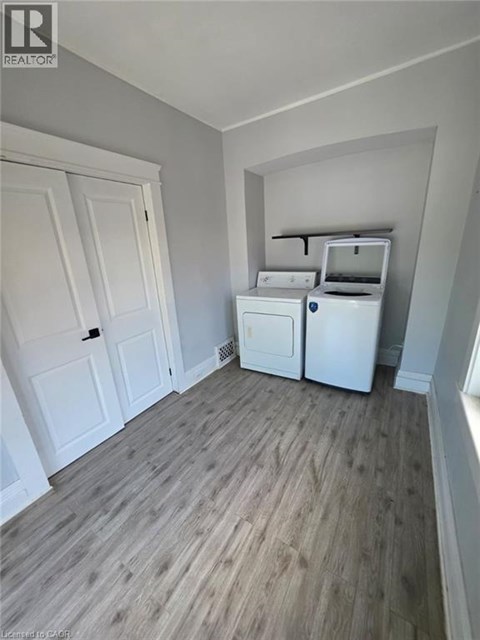 A kitchen area with a fridge, dishwasher and a washing machine.