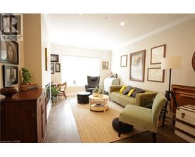 A living room with a couch, chair, and potted plants.