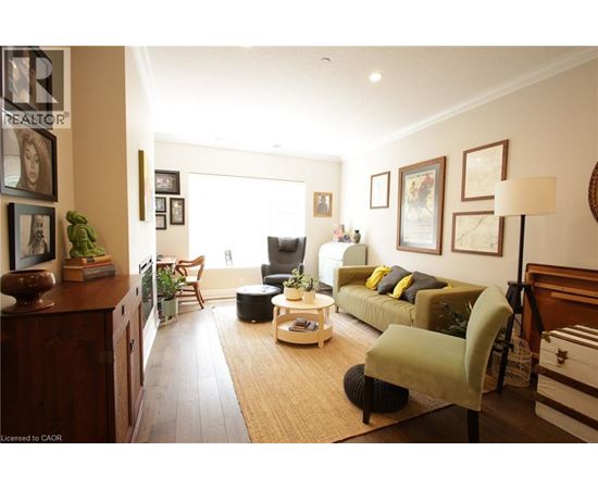 A living room with a couch, chair, and potted plants.