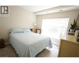 A bedroom with a bed, nightstand, and window.