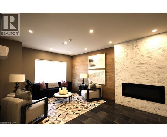 A well-lit living room with a stone fireplace and a patterned rug.