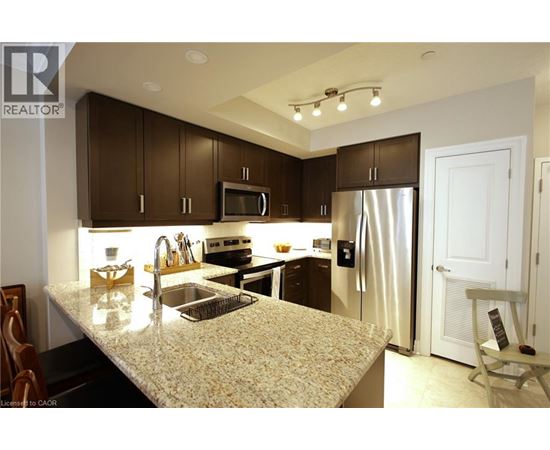 A kitchen with brown cabinets and a granite countertop.