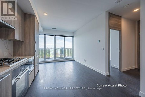 A modern kitchen with a stove top oven and a large window.
