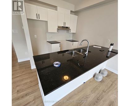 A kitchen with black countertops and white cabinets.