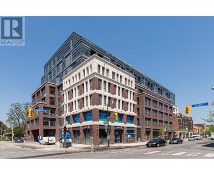 A street view of a multi-story building with a clear blue sky above.