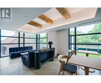 A living room with a black couch and wooden furniture.