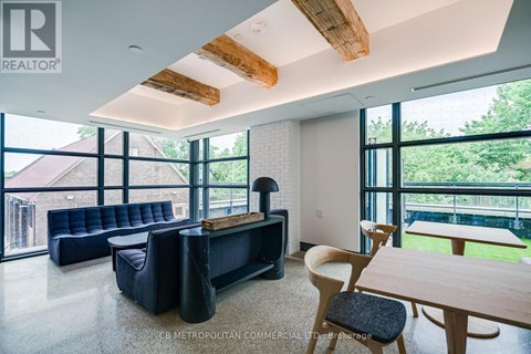 A living room with a black couch and wooden furniture.