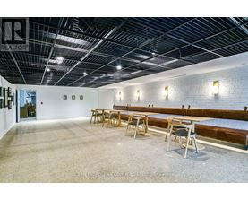 A spacious room with a long table and chairs.