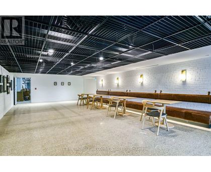 A spacious room with a long table and chairs.
