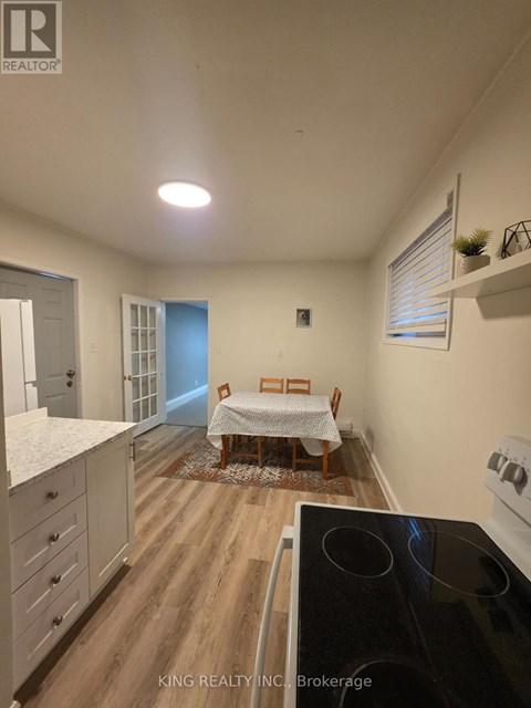 A kitchen with a dining table and chairs in the middle of the room.