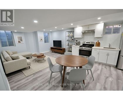 A well-lit kitchen and living room with a dining table and chairs.