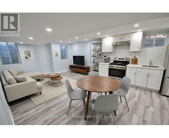A well-lit kitchen and living room with a dining table and chairs.