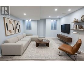 A living room with a grey sofa, a brown leather chair, and a wooden coffee table.