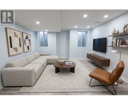 A living room with a grey sofa, a brown leather chair, and a wooden coffee table.