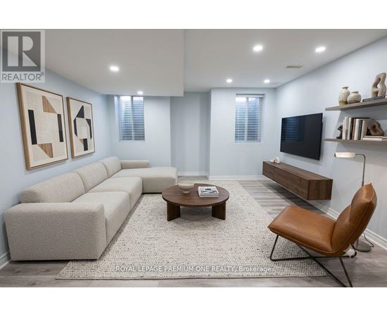A living room with a grey sofa, a brown leather chair, and a wooden coffee table.