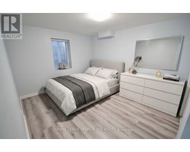 A bedroom with a bed, nightstand, and a mirror.