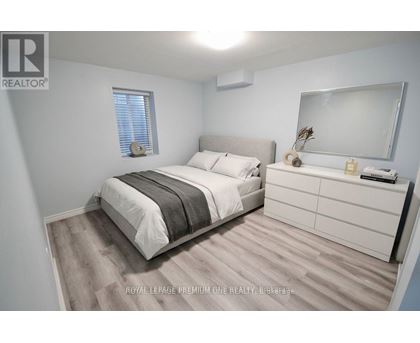 A bedroom with a bed, nightstand, and a mirror.