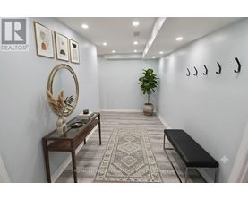 A hallway with a bench, a mirror, and a rug.