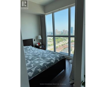 A bedroom with a large bed and a view of the city.