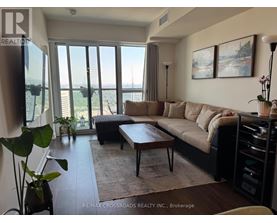A living room with a large window and a view of the city.