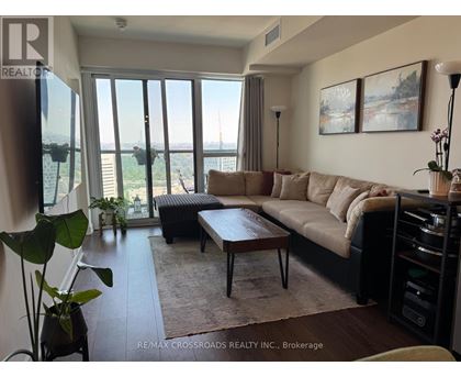 A living room with a large window and a view of the city.