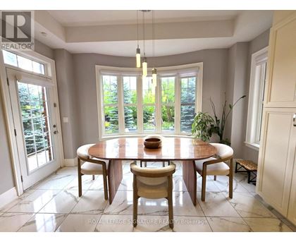 A dining room with a round table and chairs.