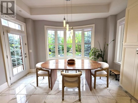 A dining room with a round table and chairs.