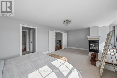 A bedroom with a large bed and a fireplace.