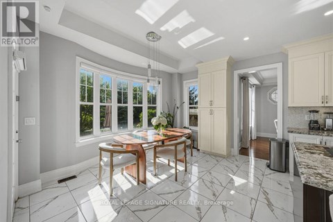 A well-lit kitchen with a dining table and chairs in the middle.