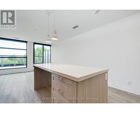 A spacious office room with a large desk and a view of the outdoors through the windows.