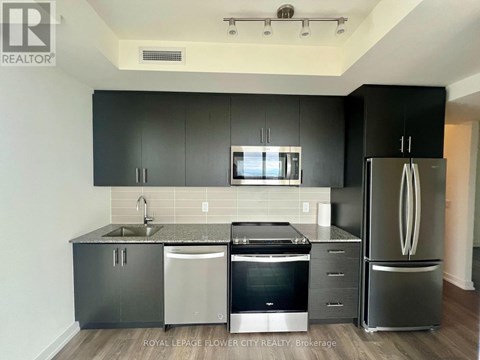 A kitchen with black cabinets and stainless steel appliances.